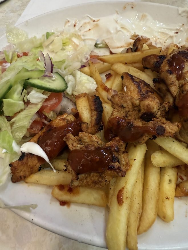 A close plate of chicken and chips with lettuce garnish